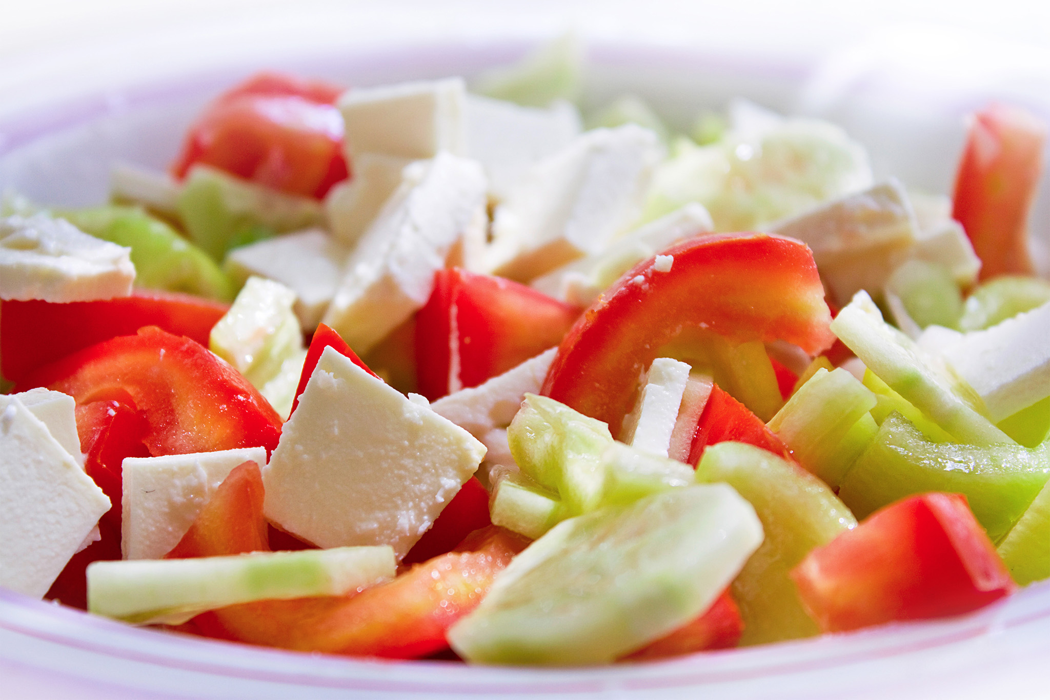 Close-up of freshly chopped tomato, cucumber, and cheese salad
